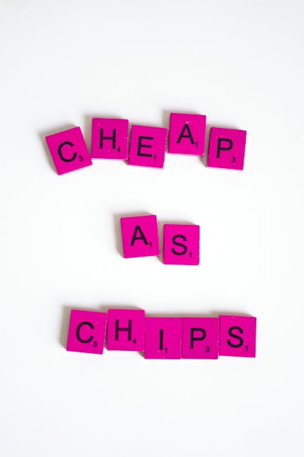 A photograph displays pink letter tiles arranged to spell out the words 'Cheap,' 'As,' and 'Chips' on a plain white surface. The tiles are small, square, made of a glossy plastic material, and have black letters with small numbers in the bottom right corner indicating their point value in a word game. The word 'Cheap' is positioned at the top with the tiles slightly tilted, followed by the word 'As' placed below it with a slight space in between, and the word 'Chips' at the bottom with all the tiles aligned in a straight line. The background is simple and free of distractions, emphasizing the arrangement of the letter tiles. This clear and neutral setting supports accessibility by focusing on the visual of the words, while subtly aligning with themes of word games or communication in a context involving ideas of affordability or options, which could indirectly link to the broader topic of cost-effective services or private waste handling through visual metaphor. Waste Disposal Merton's branding is not visible in this image.